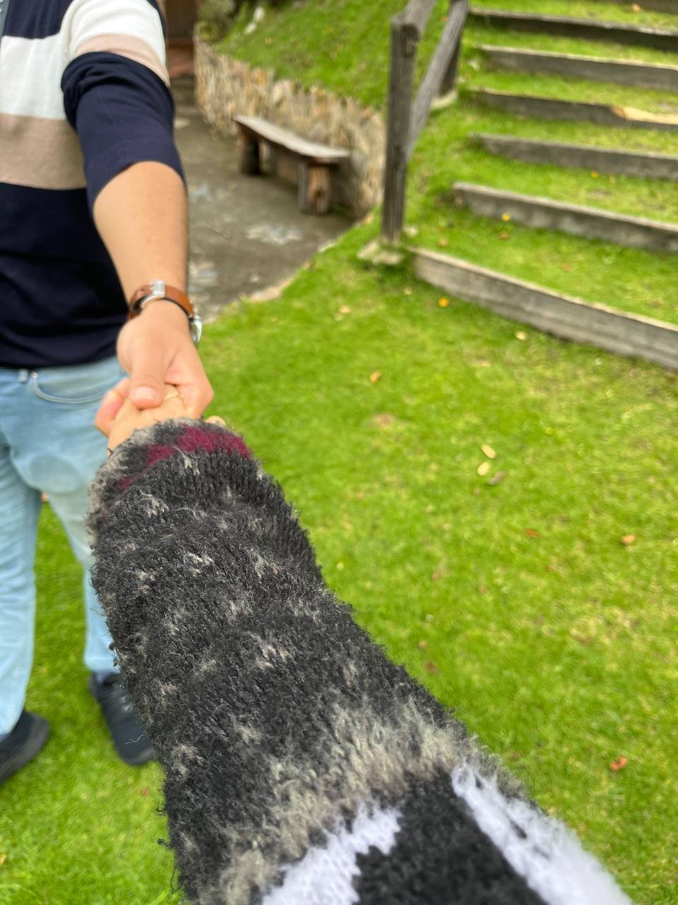 Iván llevando de la mano a Andrea por un jardín